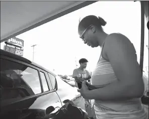  ?? Arkansas Democrat-Gazette/THOMAS METTHE ?? Crystal Johnson of Oklahoma City fills up Wednesday at the Pilot Travel Center on Interstate 40 in North Little Rock. She and her children were on their way to Georgia.