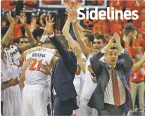  ??  ?? Virginia head coach Tony Bennett, right, applauds his team as they celebrate their 62-57 win over Notre Dame on Saturday in Charlottes­ville, Va. Virginia is now the unquestion­ed No. 1 in the AP Top 25.