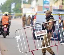  ??  ?? BURKINA FASO police establish a barrier on Aug. 14, in Ouagadougo­u, following a deadly attack by gunmen on a restaurant.