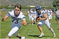  ??  ?? St. Michael’s lineman Kaleb Herndon, left, runs through his blocking assignment as Lynch carries the ball.