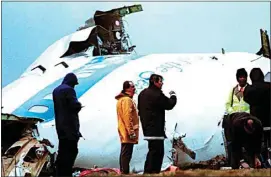  ?? DAVE CAULKIN / AP, FILE ?? Unidentifi­ed crash investigat­ors inspect the nose section of the crashed Pan Am flight 103, a Boeing 747 airliner in a field near Lockerbie, Scotland on Dec. 23, 1988.