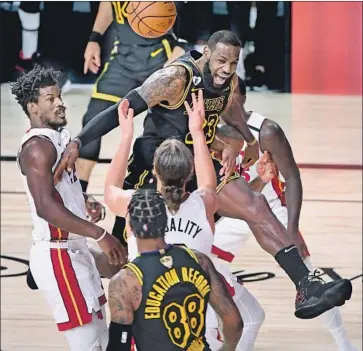  ?? Wally Skalij Los Angeles Times ?? L e BRON JAMES, fouled by Miami’s Jimmy Butler, left, while going for a rebound in the fourth quarter of Game 2 of the NBA Finals, helped push aside the Heat star’s pregame guarantee of a victory.