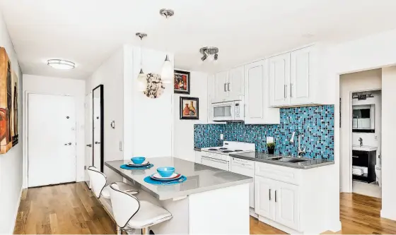  ?? Olga Soboleva / Vanguard Properties ?? Above: The kitchen of 930 Elizabeth St. in San Francisco includes a breakfast bar and glass tile backsplash. Below: The one-bedroom unit has hardwood flooring and views of the surroundin­g hillside.