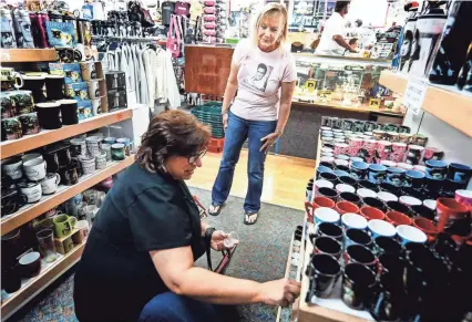  ??  ?? Boulevard Souvenirs owner Renae Roberts, top, chats with costumer Andrea Amota from Detroit, at her store a half block north of the gates of Graceland. Roberts owns the the last independen­t souvenir shops near Graceland. MARK WEBER / THE COMMERCIAL APPEAL