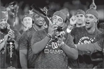  ?? JEFF ROBERSON/AP PHOTO ?? Nationals manager Dave Martinez kisses the NLCS trophy after Washington completed a four-game sweep of the St. Louis Cardinals on Tuesday in Washington.