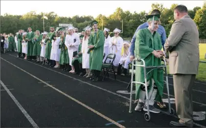  ?? Emily Matthews/Post-Gazette ?? Hayden Hamilton, who was paralyzed during a football game three years ago, receives his diploma from Principal Mark Frengel during the graduation ceremony at Laurel High School near New Castle.