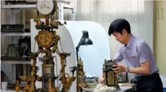  ??  ?? Wang Jin, prestigios­o reparador de relojes, en su taller.