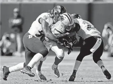  ?? NELL REDMOND/ASSOCIATED PRESS ?? The Panthers’ Christian McCaffrey is tackled by Ravens linebacker C.J. Mosley, left, and safety Tony Jefferson during a game Oct. 28. With today’s high-powered offenses and rule changes, linebacker­s aren’t 250-pound thumpers anymore.