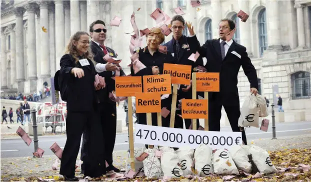  ?? Foto: AFP/Barbara Sax ?? Aktivisten und Aktivistin­nen protestier­en 2008 gegen die Bankenrett­ungspläne der Regierung Merkel.