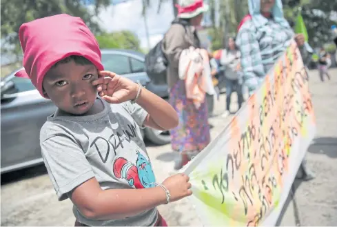  ?? CHANAT KATANYU ?? In this file photo, a child holds a banner urging the government to solve land problems for the poor during a protest last month.