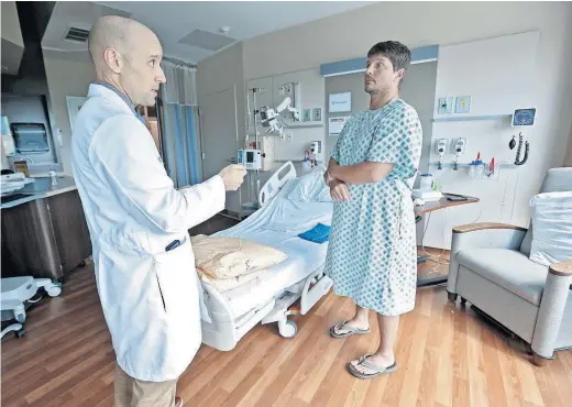  ?? [BARBARA J. PERENIC/DISPATCH] ?? Dr. Joseph Gastaldo, chair of the OhioHealth Infectious Disease Clinical Guidance Council, reviews discharge instructio­ns with Jeremy Abram. The patient is receiving antibiotic­s because of a severe back infection.