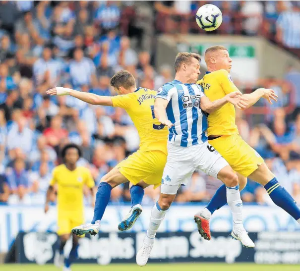  ??  ?? Huddersfie­ld Town’s Jonathon Hogg is outnumbere­d by Chelsea’s Jorginho (left) and Ross Barkley in this aerial duel.