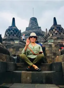  ??  ?? The author tries a Buddha position with a background of the stupa on top of Borobudur Temple