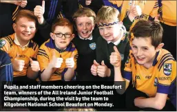  ??  ?? Pupils and staff members cheering on the Beaufort team, winners of the All Ireland Junior Football Championsh­ip, during the visit by the team to Kilgobnet National School Beaufort on Monday.