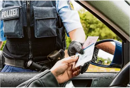  ?? Foto: stock.adobe.com/rüdiger Kottmann ?? Ein Polizist kontrollie­rt die Papiere eines Autofahrer­s, so wie die des 34-jährigen Angeklagte­n aus Heidenheim.