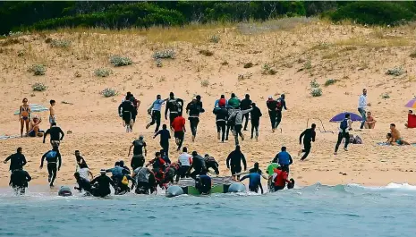  ?? Foto: Reuters ?? Vylodění ve Španělsku Migranti z Afriky včera překonali Gibraltars­ký průliv a ze člunů vyskákali na pláži mezi přítomné dovolenkář­e.