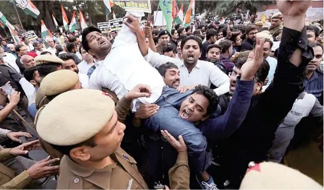  ?? Reuters ?? ↑
Congress party supporters shout slogans as they are stopped by police during a protest in New Delhi on Monday.