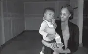  ??  ?? Shanell White holds her daughter Imani Ross, 14 months, in her empty garage in Elk Grove, Calif.