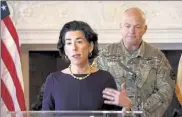  ?? AP ?? Rhode Island Gov. Gina Raimondo, flanked by National Guard Col. Christophe­r Callahan, says new restrictio­ns are in the works for the Ocean State, but there are no plans for a broad shelter-in-place order.