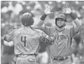  ??  ?? The Diamondbac­ks’ second baseman Ketel Marte is greeted by left fielder David Peralta at home plate after hitting a two-run home run vs. the Pirates on Thursday in Pittsburgh. CHARLES LECLAIRE/USA TODAY SPORTS