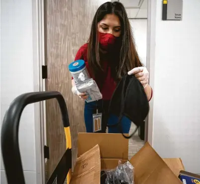  ?? Godofredo A. Vásquez / Staff photograph­er ?? Alejandra Ramos, 23, a junior paralegal clerk at AZA Law, disinfects products and face masks to place at work stations. Many companies are preparing for their employees to return to work.