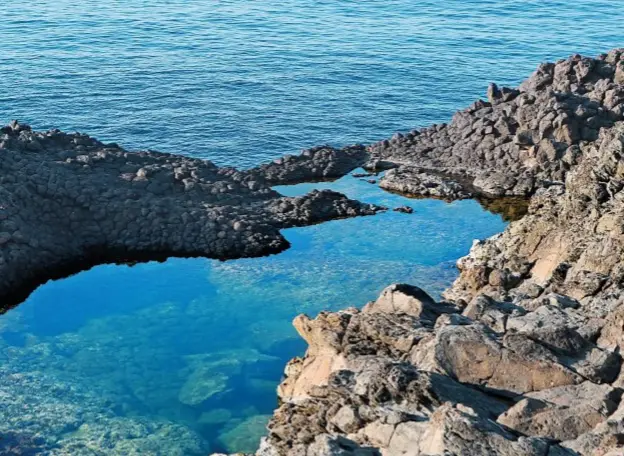  ??  ?? Il laghetto delle Ondine, dalle parti di Punta Spadillo. Sotto, il dammuso Trusco ,a Rekhale, su un promontori­o affacciato verso il tramonto.