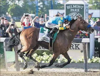  ?? SethWenig Associated Press ?? AMERICAN PHAROAH, with jockey Victor Espinoza, crosses the finish line in the Belmont Stakes to become the 12th horse to win the Triple Crown and the first since Affirmed in 1978.