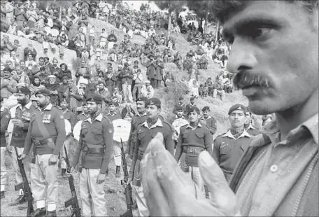  ?? Nasiruddin Mughal
European Pressphoto Agency ?? PAKISTANI TROOPS join other mourners at the funeral for a soldier near the city of Muzaffarab­ad. He was among 22 killed Sunday.