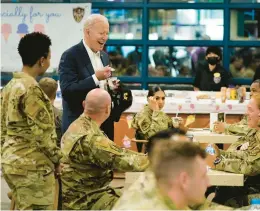 ?? EVAN VUCCI/AP ?? U.S. President Joe Biden eats ice cream during a visit with American service members on Sunday at Osan Air Base in Pyeongtaek, South Korea.