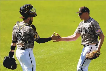  ?? K.C. ALFRED U-T ?? Padres catcher Victor Caratini celebrates with closer Mark Melancon after beating the Dodgers 5-2 at Petco Park on Sunday.