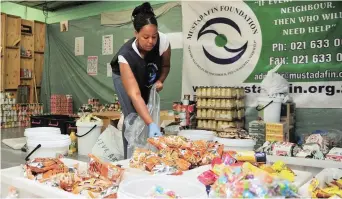  ?? PICTURE: PHANDO JIKELO/AFRICAN NEWS AGENCY/ANA ?? HELPING HANDS: Mcinga, a volunteer of the Mustadafin Foundation, packing food that will be donated to the fire victims of Valhalla Park today.