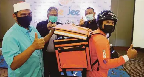  ?? PIC BY FARIZUL HAFIZ AWANG ?? State Religious Affairs chairman Datuk Seri Syed Ibrahim Syed Ahmad (left) and Ode Jee chief executive officer Yussaini Ali (second from left) giving the thumbs up at the Ode Jee applicatio­n prelaunchi­ng ceremony in Kuantan on Monday.