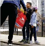  ?? ALASTAIR GRANT / ASSOCIATED PRESS
Associated ?? A boy helps with belongings as a family voluntaril­y leaves Dorney block, part of the Chalcots Estate in north London, on Saturday after the local council evacuated some 650 homes overnight.