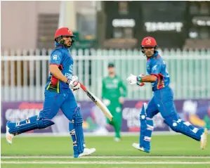  ?? AFP ?? Afghanista­n’s Gulbadin Naib (left) and Rashid Khan Arman run between the wickets during the first ODI against Ireland at the Sharjah Cricket Stadium on Tuesday. —