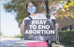  ?? LM OTERO — THE ASSOCIATED PRESS ?? Maria Peña holds a rosary and sign out outside a building housing an abortion provider in Dallas on Thursday.