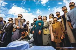  ?? MARCUS YAM LOS ANGELES TIMES ?? Mourners at a mass funeral look up as the roar of jet engines drown out their wails in Kabul, Afghanista­n, on Aug. 30, 2021. Photograph­er Marcus Yam received a Pulitzer Prize on Monday for his coverage of the fall of Kabul to the Taliban.
