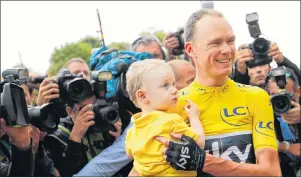  ?? AP PHOTO ?? Tour de France winner Britain’s Chris Froome, wearing the overall leader’s yellow jersey, holds his son Kellan after the twenty-first and last stage of the Tour de France cycling race over 103 kilometers with start in Montgeron and finish in Paris,...