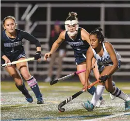  ?? JOHN GILLIS/FOR BALTIMORE SUN MEDIA ?? River Hill’s Puja Nanjappa, right, moves the ball against Marriotts Ridge’s Natalie Freeman, left, and Marin Kriner during the second half of Wednesday’s Class 3A state semifinal game at Glen Burnie.