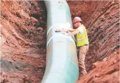  ?? Richard Tsong-taatarii / Star Tribune via the Asociated Press Files ?? A pipe fitter lays the finishing touches in 2017 to the replacemen­t of Enbridge Energy’s Line 3 crude oil pipeline stretch in Superior, Minn.