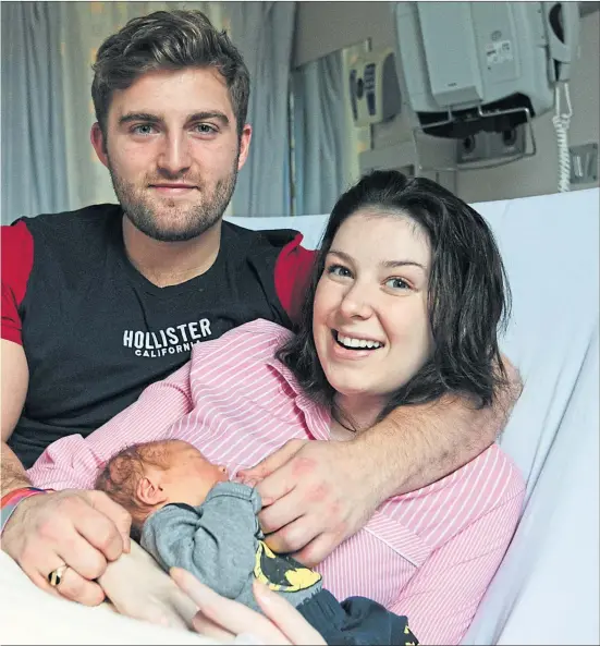  ??  ?? Lucy Lintott, partner Tommy Smith and baby LJ in maternity ward, above, and, left, LJ holds Lucy’s finger