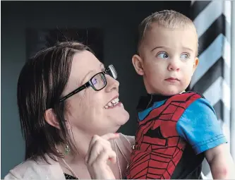  ?? PAUL DALY THE CANADIAN PRESS ?? Kelly Knee holds her youngest son, 20-month-old Jacob who was born after Knee underwent treatment for cancer, at home in Torbay N.L. on Monday.