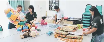  ??  ?? Hope Place founder Kelvin Wan (second right) and his Hope Place team seen packing Christmas presents to be brought along for CWB5.