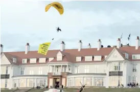  ?? AP ?? A Greenpeace protester flying a microlight passes over President Trump’s resort in Turnberry, Scotland, with a banner reading “Trump: Well Below Par.’’ Scottish police said the protester breached a no-fly zone and committed a criminal offense.