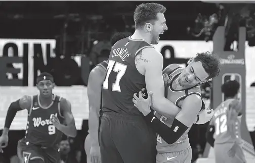  ??  ?? WORLD forward Luka Doncic of the Dallas Mavericks reacts with USA guard Trae Young of the Atlanta Hawks during the NBA Rising Stars basketball game at United Center. Kyle Terada, USA TODAY Sports via Reuters