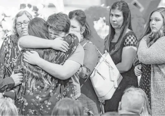  ?? Brett Coomer / Houston Chronicle ?? Mourners embrace the family of Christian Riley Garcia as they pay their last respects to the teenager during his funeral at Crosby Church on Friday. The 15-year-old Santa Fe High School student was heralded for helping classmates escape the mass...