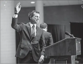  ?? MICHAEL CATERINA/SOUTH BEND TRIBUNE VIA AP ?? Former South Bend Mayor Pete Buttigieg waves to supporters before ending his presidenti­al campaign during a speech to supporters, March 1, 2020, in South Bend, Ind. He is now the transporta­tion secretary.