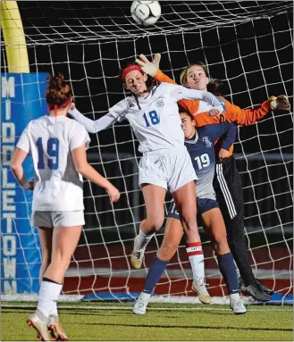 ?? SEAN D. ELLIOT/THE DAY ?? Old Lyme goalie Samantha Gray leaps over Immaculate’s Henny Rodriguez (19) and teammate Caroline Wallace (18) to tip the ball out of the box in the first half of the CIAC Class S girls’ soccer tournament final on Sunday at Middletown High School.