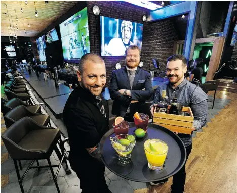  ?? MARK VAN MANEN/PNG ?? Bartender Justin Taylor, left, Shark Club bar manager Andrew Young and bartender Shaun Layton in the newly renovated sports bar in Vancouver.