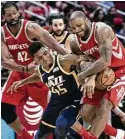  ?? Marie D. De Jesus / Houston Chronicle ?? High-scoring guard Donovan Mitchell, is surrounded by Nene, left, and P.J. Tucker during the Jazz rookie’s first encounter with the Rockets.