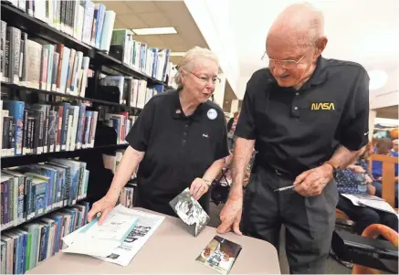  ?? PHOTOS BY ?? Bill Weppner, a former NASA flight controller who worked on the space program’s Apollo missions, chats with Rose Ann Bradley as he signs a few photos before giving a talk about his experience­s Tuesday at the Germantown library. JOE RONDONE/THE COMMERCIAL APPEAL